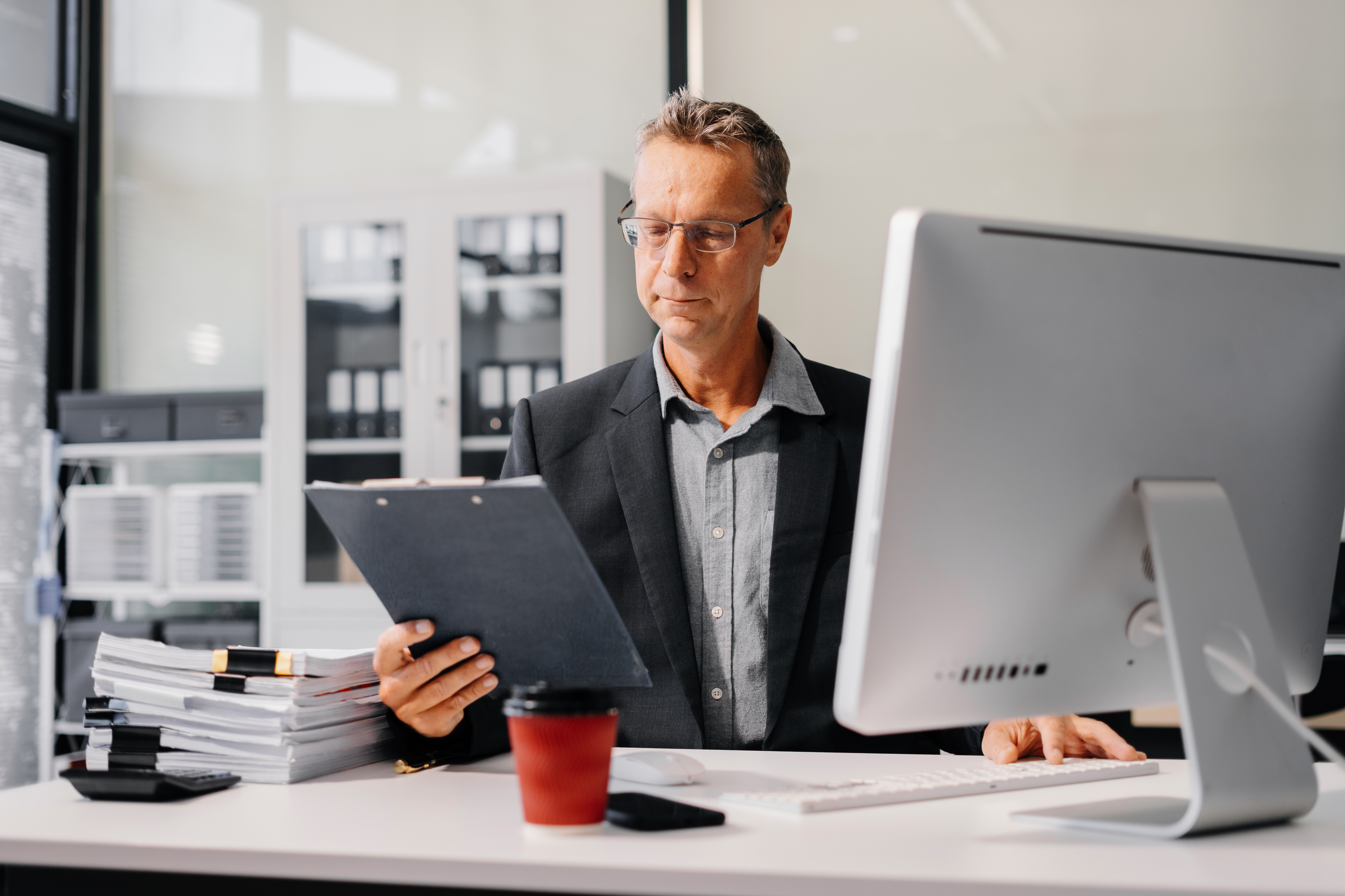 two male workers smiling while looking at laptop